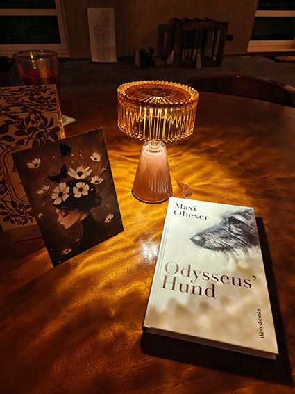 Erleuchtete Lampe, Buch und Bild auf einem Tisch